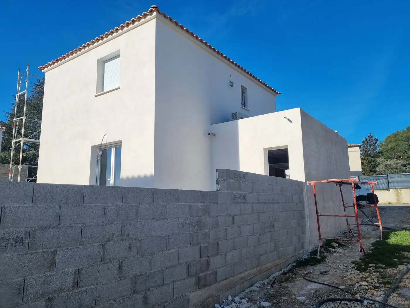 Mur de clôture et maison neuve
